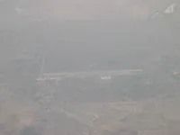 Military airfield with single runway, support complex and adjacent town
