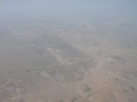 Airfield in semi-arid terrain with circular irrigated fields nearby