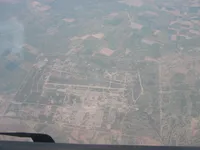 Large military airfield with runway/taxiway system and extensive support area amid farmland