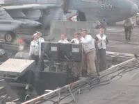 CVW-7 Landing Signal Officers (LSOs) with partial VAQ-140 Patriots Prowler behind them