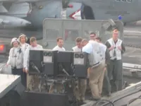 CVW-7 Landing Signal Officers (LSOs) with partial VAQ-140 Patriots Prowler behind them